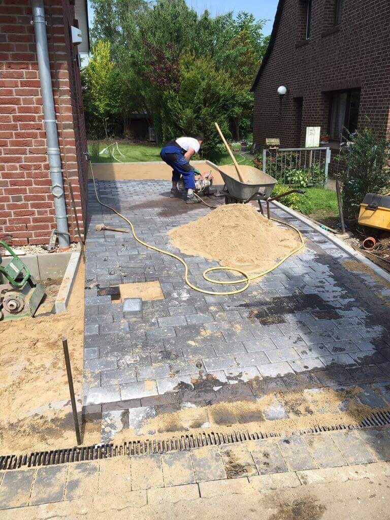 die pflastersteine werden auf der einfahrt verlegt die pflastersteine werden auf der einfahrt verlegt