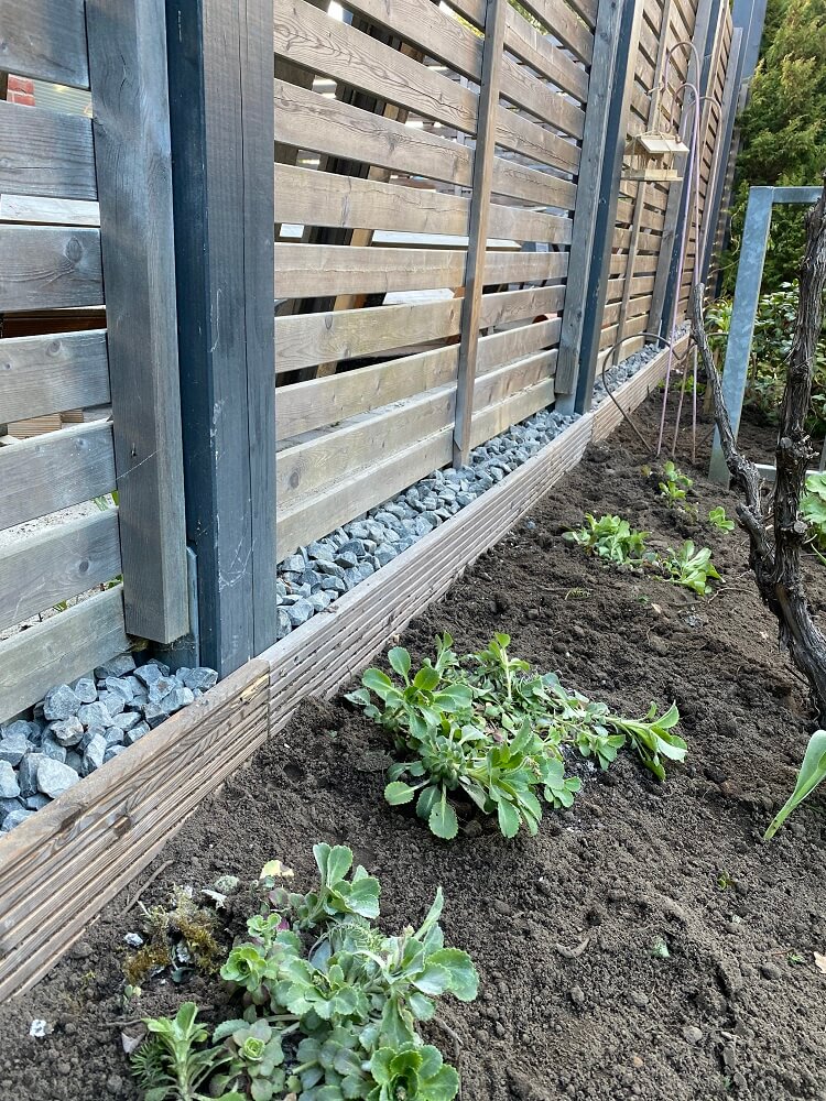 Damit unsere Nachbarn nicht das hรคssliche Betonfundament anschauen mรผssen, haben wir eine Holzblende montiert und mit Steinen dekoriert